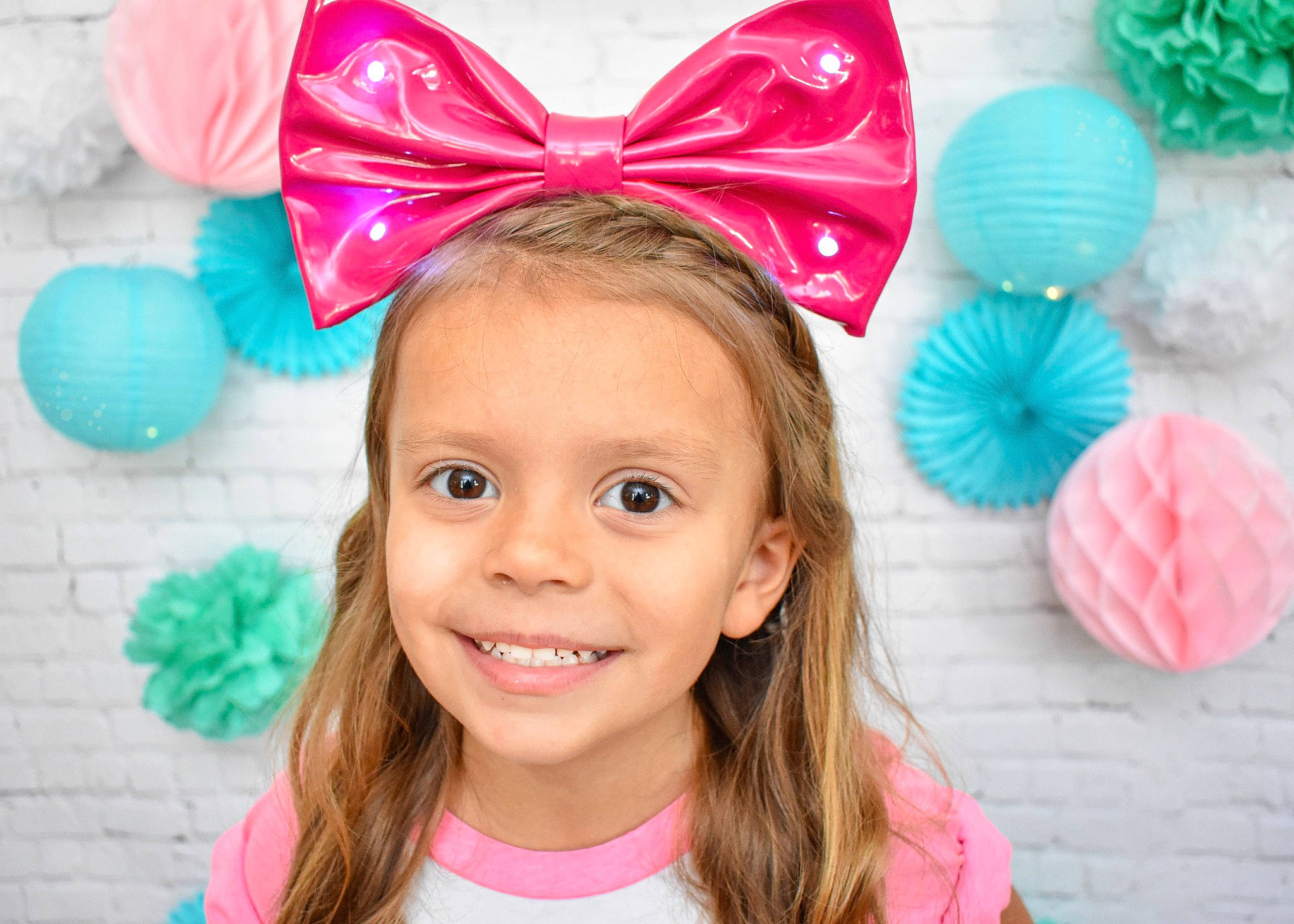 Olivia is registered to the contest to win money with this photo: child, clothing, ear, fashion_accessory, hair_accessory, headband, headgear, joy, party_supply, person, pink, smile, toddler, turquoise