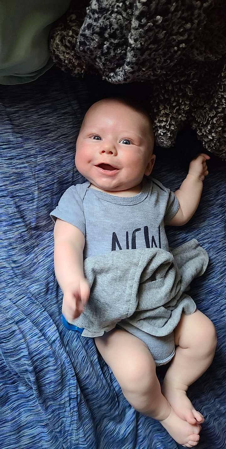 Ivan is registered to the contest to win money with this photo: baby, baby_toddler_clothing, cheek, eye, face, facial_expression, finger, flash_photography, grass, grey, happy, head, iris, lip, person, product, purple, skin, sleeve, smile