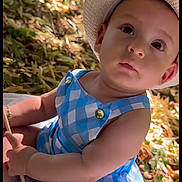 Joseph participe au concours pour gagner de l'argent avec cette photo : arm, baby, blanket, blue_checkered, child, curious, cute, face, hand, hat, leafy_background, nature, outdoors, person, portrait, sitting, skin, summer, sunlight, young