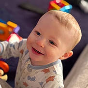 Ryder joined the competition — help win amazing prizes! baby, infant, smiling, onesie, pajamas, face, head, toys, colorful, blanket, bed, close_up, portrait, cute, teeth, ear, hand, indoor, play, happy