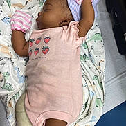 Amira is registered to the contest to win money with this photo: baby, sleeping, pink_onesie, mittens, hospital_cap, blanket, dinosaur_print, infant, newborn, medical_table, cute, peaceful, child, portrait, indoors, laying_down, soft_fabric, cozy, small_person, toddler