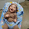 Mario joined the competition — help win amazing prizes! baby, child, smiling, hoodie, brown_clothing, baby_chair, animal_print, happy, indoor, floor, kitchen, appliance, seat, playful, cute, infant, person, portrait, casual, expression