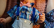 Mario is registered to the contest to win money with this photo: baby, child, infant, plaid_shirt, bow_tie, suspenders, shorts, blanket, quilt, lying_down, legs, hands, expression, cute, indoor, person, clothing, pattern, fabric, colorful