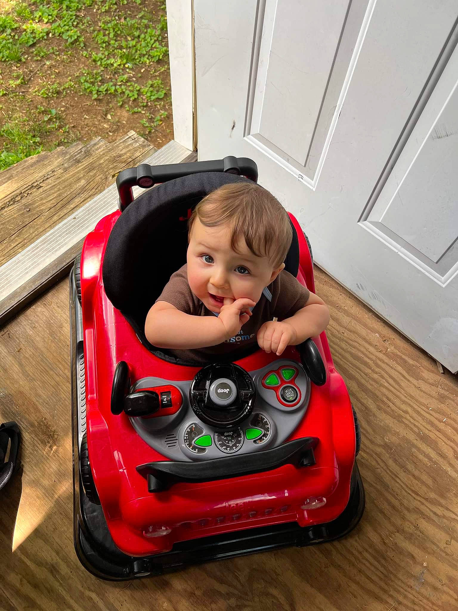 Harley is registered to the contest to win money with this photo: automotive_design, automotive_exterior, automotive_lighting, automotive_tire, automotive_wheel_system, baby, bumper, car, grass, happy, hood, motor_vehicle, person, plant, riding_toy, tire, toddler, toy, vehicle, vehicle_door