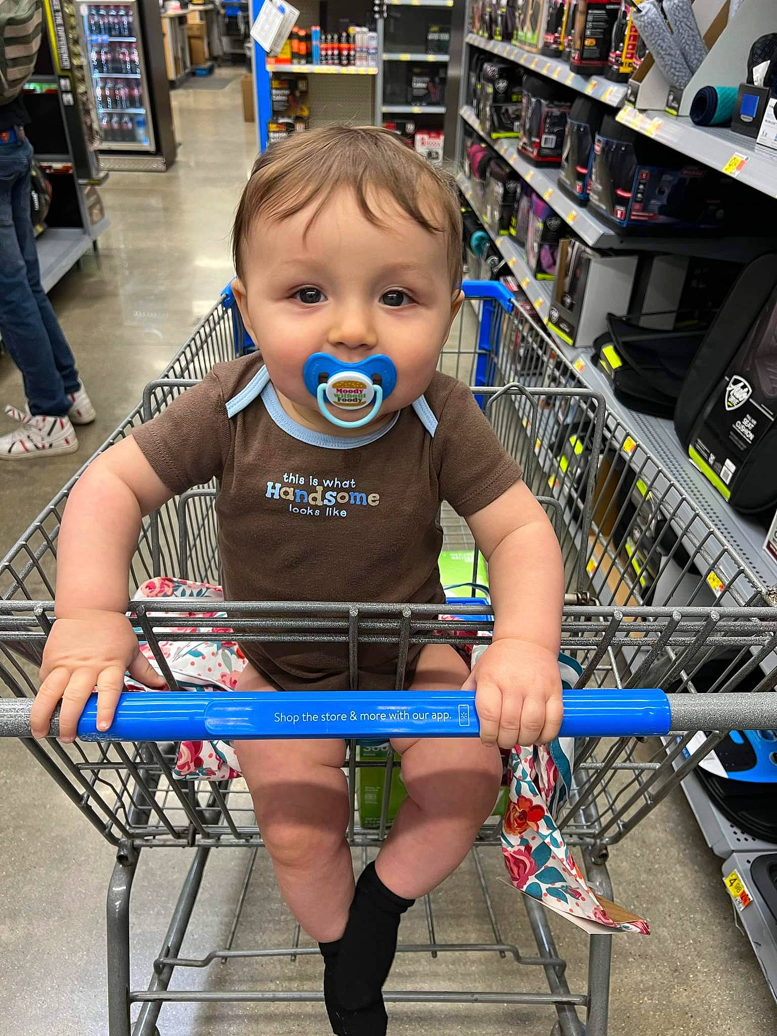 Harley is registered to the contest to win money with this photo: child, customer, electric_blue, fun, hairstyle, joint, leg, person, photograph, product, retail, shelf, shoe, shopping, shopping_cart, snapshot, standing, thigh, tire, toddler