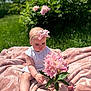 Nova joined the competition — help win amazing prizes! baby, child, flower, pink_bow, blanket, outdoor, grass, greenery, sunlight, nature, curious, sitting, headband, soft_texture, flora, person, cute, infant, summer, garden