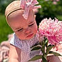 Nova is registered to the contest to win money with this photo: baby, child, flower, pink_bow, pink_flower, outdoor, nature, portrait, close_up, cute, sunlight, greenery, infant, soft_focus, summer, skin, hand, dress, headband, peaceful