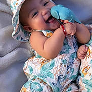 Valentina is registered to the contest to win money with this photo: baby, child, smile, hat, toy, whale, blanket, clothing, happy, cute, infant, playing, cheerful, patterned_outfit, relaxing, soft_texture, skin, arm, leg, portrait