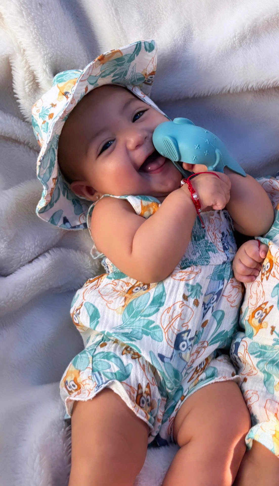 Valentina is registered to the contest to win money with this photo: baby, child, smile, hat, toy, whale, blanket, clothing, happy, cute, infant, playing, cheerful, patterned_outfit, relaxing, soft_texture, skin, arm, leg, portrait
