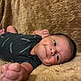 Jexiel E. joined the competition — help win amazing prizes! baby, infant, smile, clothing, onesie, calvin_klein, fist, blanket, soft_texture, lying_down, cheek, face, skin, happy, cute, child, portrait, human, young, indoors