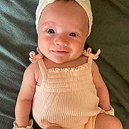 Leilani is registered to the contest to win money with this photo: baby, infant, smile, romper, mittens, headband, bow, lying_down, blanket, closeup, cute, skin, child, adorable, happy, young, portrait, baby_clothes, infant_fashion, soft_texture