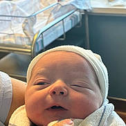 Asher is registered to the contest to win money with this photo: newborn, baby, infant, swaddled, blanket, hospital, cap, hand, sleepy, closeup, face, person, indoor, bed, bassinet, window, soft, skin, cute, tender