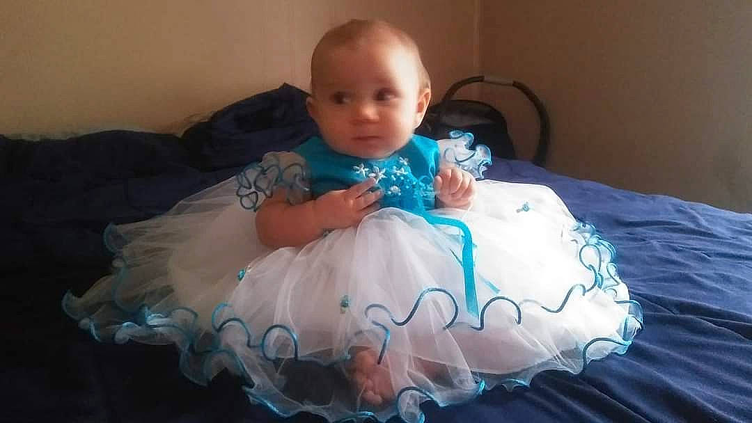 Kenzie Grace joined the competition — help win amazing prizes! baby, baby_toddler_clothing, bed, comfort, dress, electric_blue, embellishment, event, face, flash_photography, fun, happy, iris, linens, pattern, person, room, shoulder, sitting, textile