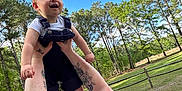 Matthew joined the competition — help win amazing prizes! baby, casual_clothing, child, daylight, family, fence, grass, happy, holding, joy, nature, outdoor, person, playing, red_hair, sky, smiling, tattoo, trees, woman