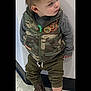 Creed is registered to the contest to win money with this photo: toddler, child, boy, standing, camouflage_vest, gray_shirt, olive_pants, cowboy_boots, curious, indoor, floor_tiles, white_wall, looking_away, casual_clothing, young_child, short_hair, candid, portrait, footwear, fashion