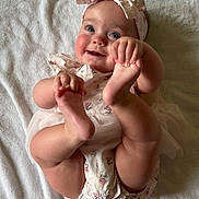 Emilia joined the competition — help win amazing prizes! baby, infant, smile, headband, barefoot, hands, feet, white_blanket, cute, portrait, child, happy, lying_down, soft_texture, skin, clothing, person, toddler, playful, indoors