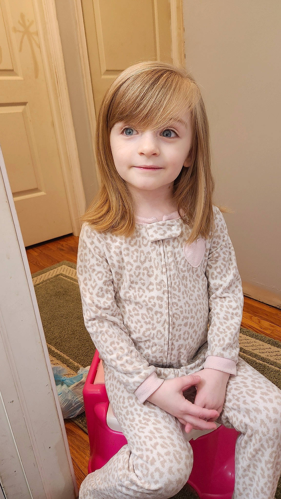 Emmalyn is registered to the contest to win money with this photo: arm, baby_toddler_clothing, bangs, blond, cabinetry, child, door, embellishment, event, fashion_design, flooring, hairstyle, hardwood, joy, layered_hair, pattern, person, sitting, skin, sleeve