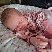 Emma is registered to the contest to win money with this photo: baby, bed, blanket, child, cozy, cute, face, floral, hand, indoors, infant, newborn, onesie, peaceful, pillow, portrait, resting, sleeping, soft, toddler
