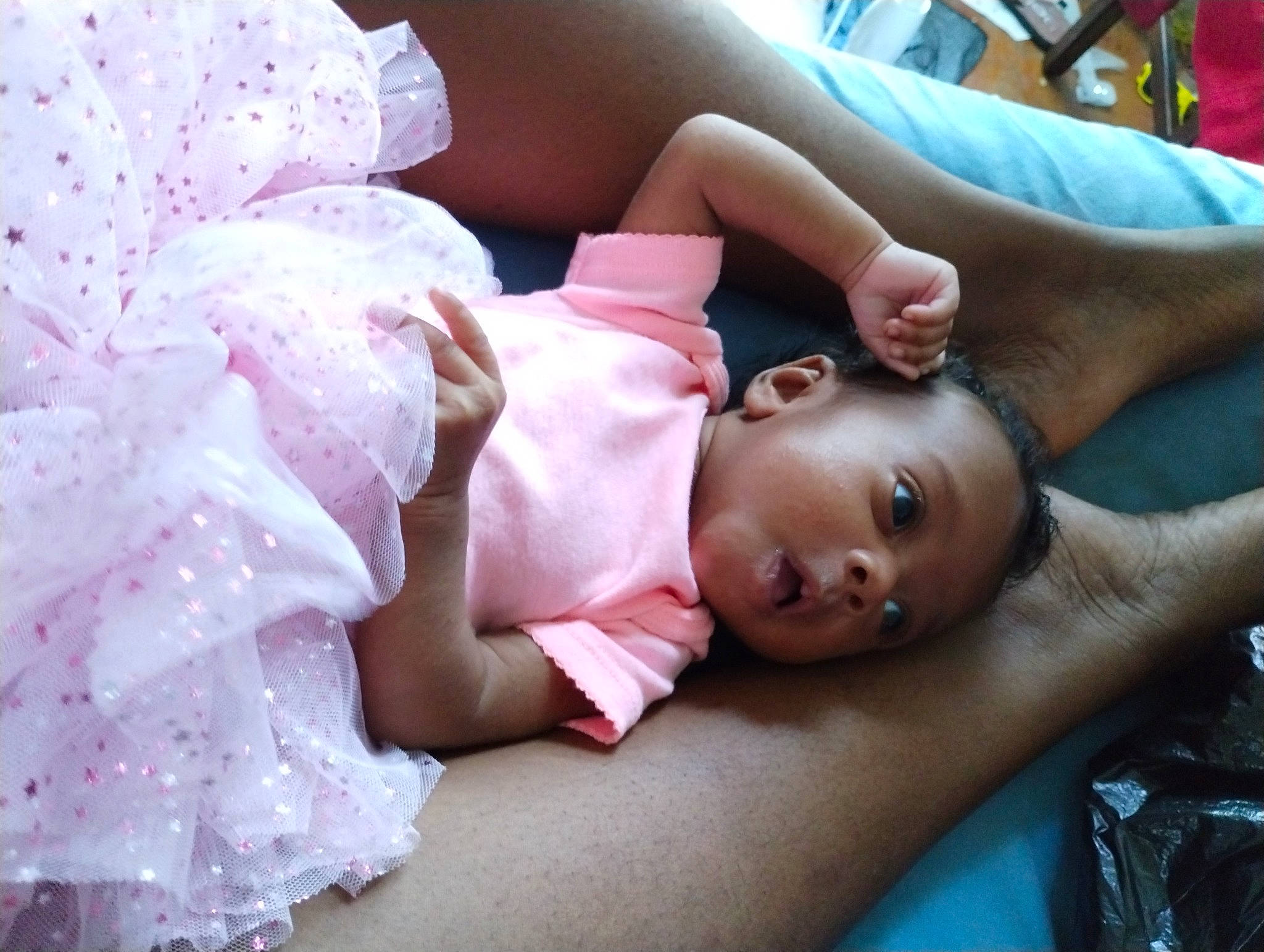 Amani is registered to the contest to win money with this photo: baby, baby_toddler_clothing, chest, child, comfort, couch, event, eyelash, fun, happy, headpiece, linens, mouth, person, petal, pink, product, room, skin, textile