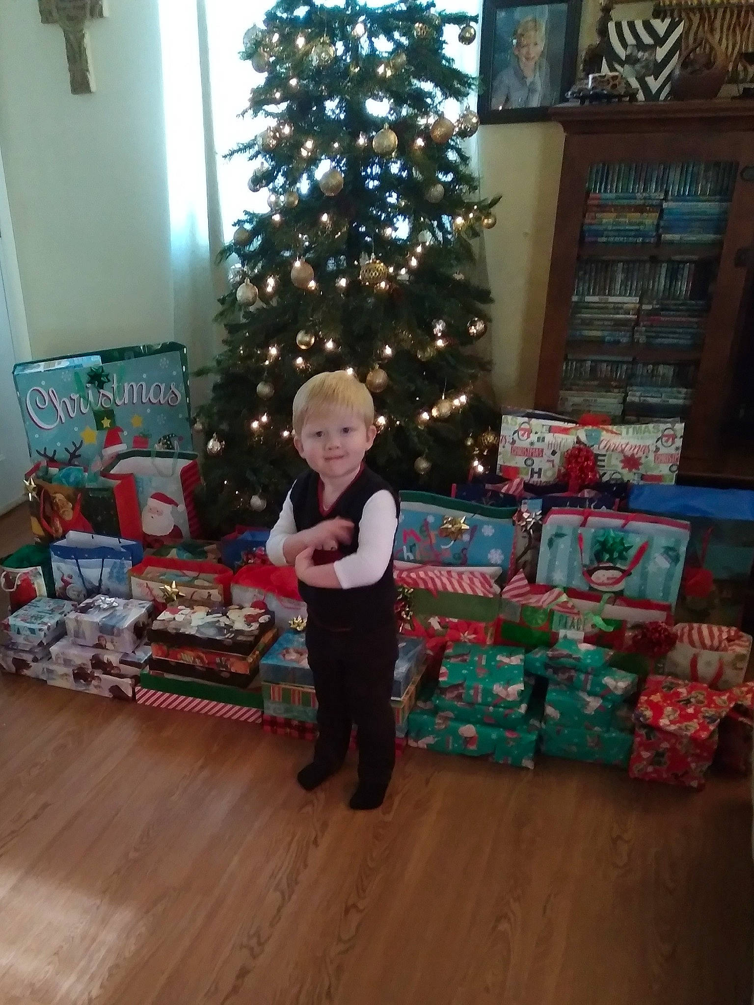 Weston is registered to the contest to win money with this photo: christmas, christmas_decoration, christmas_eve, christmas_ornament, christmas_tree, couch, event, evergreen, flooring, fun, hardwood, holiday, holiday_ornament, joy, living_room, ornament, person, plant, room, smile