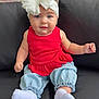 baby, child, blue_eyes, headband, white_bow, red_top, light_blue_pants, white_socks, couch, black_couch, brick_wall, sitting, indoors, cute, portrait, person, smiling, baby_clothing, infant, adorable
