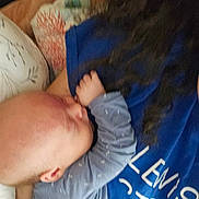 Rheis joined the competition — help win amazing prizes! baby, infant, child, person, blue_clothing, onesie, hair, hand, face, sleeping, resting, nursing, closeup, intimate, comfort, blanket, pillow, bed, indoor, soft_lighting