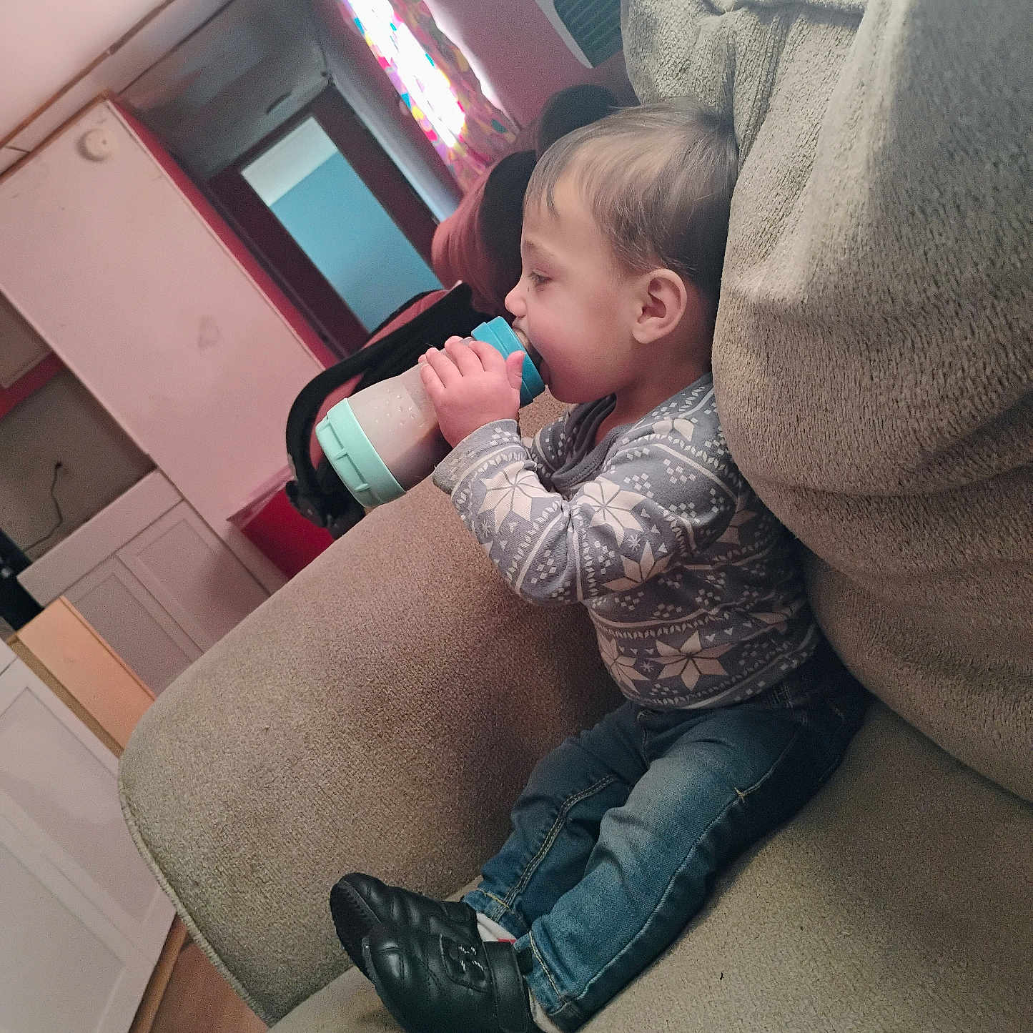 Nathan joined the competition — help win amazing prizes! baby, bottle, child, clothing, couch, curtain, drink, face, floor, furniture, indoor, jeans, light, person, room, shoe, sitting, sweater, toddler, window