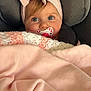 baby, infant, pacifier, headband, bow, car_seat, blanket, pink_blanket, crochet_blanket, blue_eyes, chubby_cheeks, cute, portrait, cozy, fabric, seat_strap, soft, gaze, cuddly, eyelashes