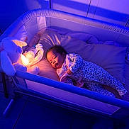 Arcadia is registered to the contest to win money with this photo: baby, bedroom, child, cozy, crib, floor_tiles, home, indoor, infant, lighting, nightlight, pajamas, person, pillow, relaxing, sleeping_area, sleepwear, soft_toy, stuffed_animal, toy