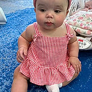 Leilani joined the competition — help win amazing prizes! baby, child, infant, red_gingham_dress, headband, socks, blue_carpet, indoor, nursery, blanket, baby_bouncer, curious_expression, seated, cute, playful, two_babies, soft_lighting, home, floor, portrait