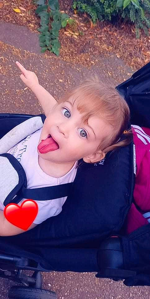 Julyanna participe au concours pour gagner de l'argent avec cette photo : baby, baby_products, baby_toddler_clothing, carmine, cheek, child, facial_expression, fun, grass, happy, leisure, lip, person, pink, play, sitting, surprise, toddler, toy, vacation