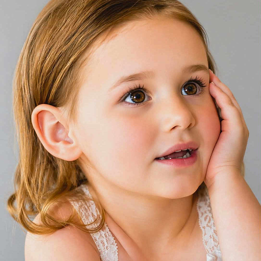 Leiadawn joined the competition — help win amazing prizes! child, girl, portrait, face, close_up, smiling, curious, looking_up, brown_hair, blue_eyes, studio, gray_background, white_dress, lace, hand_on_cheek, shoulders, indoor, photography, adorable, young_child