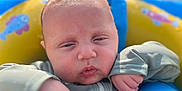 Kaesyn is registered to the contest to win money with this photo: baby, blue, child, closeup, expression, face, float, hand, infant, outdoor, person, play, skin, summer, sunlight, swimwear, water, water_toy, yellow, young