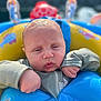 baby, blue, child, closeup, expression, face, float, hand, infant, outdoor, person, play, skin, summer, sunlight, swimwear, water, water_toy, yellow, young