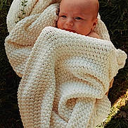 Romeo is registered to the contest to win money with this photo: baby, blanket, cozy, cream, cute, face, grass, greenery, infant, knit, nature, newborn, outdoor, peaceful, portrait, serene, skin, soft_light, warm, wrapped