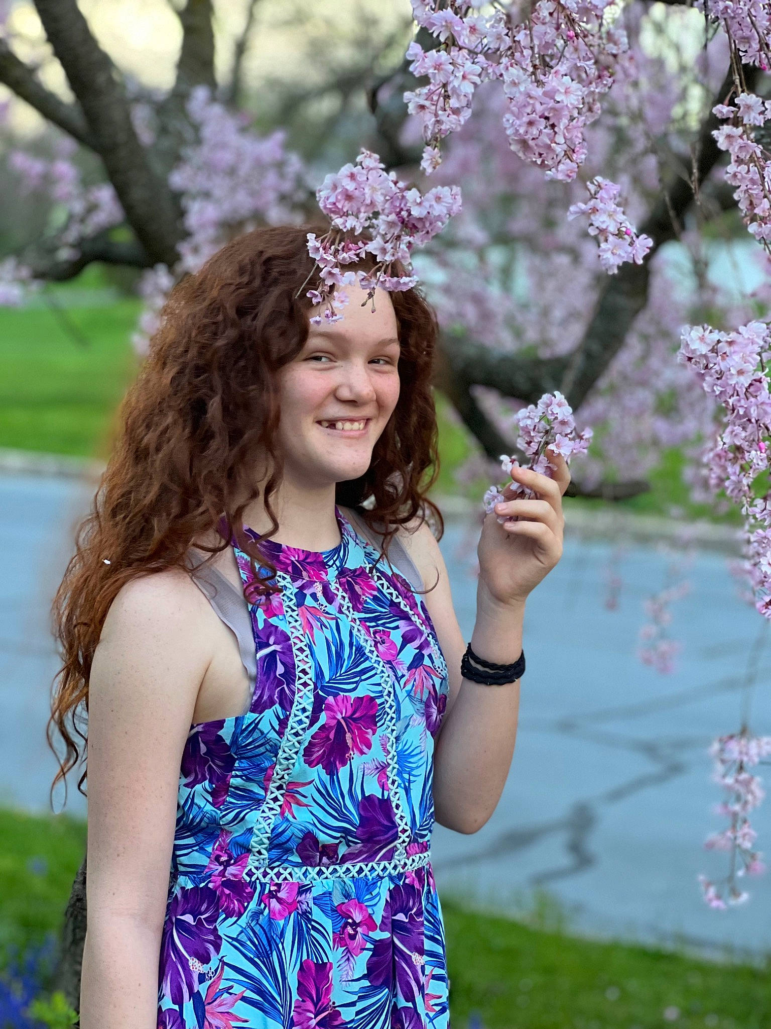 Irelyn is registered to the contest to win money with this photo: botany, branch, eye, flower, grass, green, hairstyle, happy, headwear, joy, leisure, nature, people_in_nature, person, photograph, pink, plant, purple, smile, summer