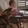 animal, baby, blanket, cat, chair, documents, family, high_chair, home, indoors, infant, pet, pink_clothing, portrait, sitting, sunlight, tabby_cat, table, window, wooden_floor