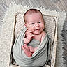 baby, infant, smile, blanket, basket, wrapped, cute, face, head, hands, feet, floor, rug, woven_basket, cozy, portrait, newborn, child, indoor, soft