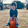 Giovanni is registered to the contest to win money with this photo: toddler, child, pumpkin, outdoor, grass, smile, happy, blue_shoes, fall, nature, casual_clothing, daylight, portrait, young_child, seasonal, playful, sitting, cute, fun, park