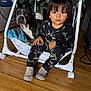 Giovanni joined the competition — help win amazing prizes! toddler, child, dog, pajamas, indoor, wooden_floor, baby_chair, pet, black_dog, white_dog, christmas_tree, holiday_decor, socks, furniture, curly_hair, face, floor, blanket, toy, cozy