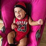 Isaiah a rejoint le concours — aidez-le/la à gagner de superbes lots ! baby, infant, child, jordan, red_clothing, hat, socks, stroller, pink, smiling, happy, cute, indoors, portrait, person, young, seated, playful, face, expression