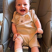 Kenzo a rejoint le concours — aidez-le/la à gagner de superbes lots ! baby, smiling, infant, child, baby_chair, beige_clothing, white_socks, happy, curly_hair, indoor, wooden_floor, cushioned_seat, cute_outfit, person, face, legs, hands, sitting, bright_eyes, joy