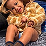 toddler, child, smiling, hoodie, bear_ears, brown, socks, bedspread, indoor, cute, happy, portrait, baby, clothing, soft_texture, warm, seated, young_child, cozy, face