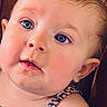 baby, blue_eyes, brown_background, cheeks, child, close_up, clothing, curious_expression, cute, face, head, indoors, infant, leopard_print, person, portrait, sitting, skin, texture, young