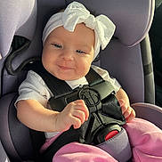 Wrynlee is registered to the contest to win money with this photo: baby, car_seat, headband, bow, pink_pants, smile, child, infant, seatbelt, safety, happy, cute, indoors, person, portrait, clothing, baby_clothes, seat, car, sunlight