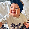 Wrynlee is registered to the contest to win money with this photo: baby, bed, child, clothing, cozy, cute, face, flower, happy, head, headband, indoor, infant, leopard_print, patterned_blanket, portrait, sitting, smiling, toddler, white_shirt