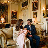 Kitty joined the competition — help win amazing prizes! baby, blanket, carpet, chandelier, cushion, dress, family, fireplace, formal_wear, infant, lamp, living_room, luxury, mantelpiece, ornate_decor, painting, parents, portrait, sofa, suit