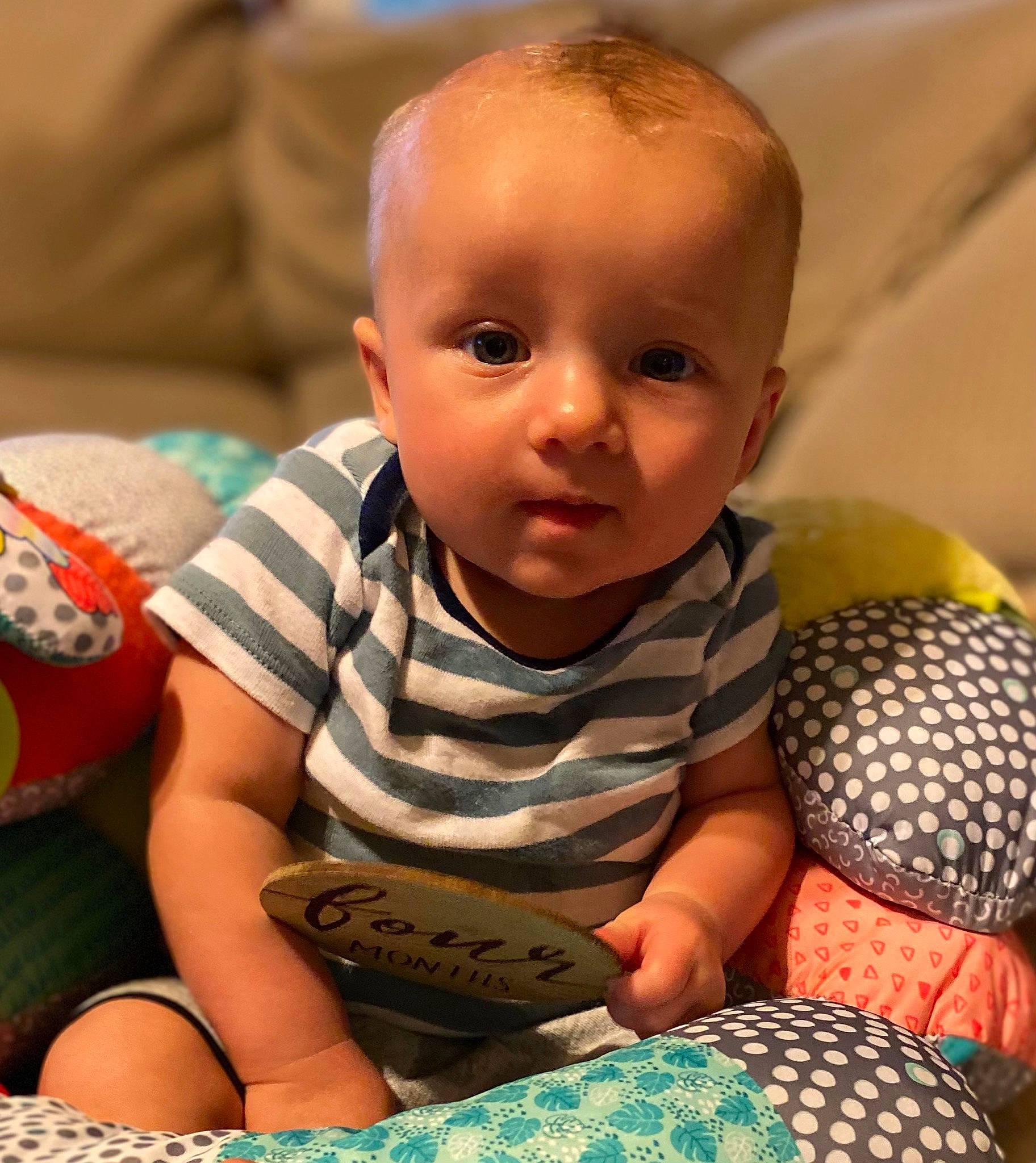 Landon is registered to the contest to win money with this photo: abdomen, audio_equipment, baby, baby_products, baby_toddler_clothing, cheek, child, comfort, fun, happy, iris, linens, pattern, person, room, sitting, skin, sleeve, smile, t_shirt
