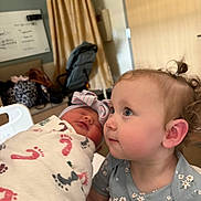 Penelope is registered to the contest to win money with this photo: toddler, newborn, baby, hospital, blanket, curly_hair, swaddled, child, portrait, indoor, cute, infant, person, blue_eyes, clothing, headband, family, love, care, curiosity