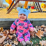 María joined the competition — help win amazing prizes! autumn, baby, child, cute, daylight, fun, grass, hat, leaves, outdoor, park, pink_clothing, play_equipment, playground, pom_pom, seasonal, slide, smiling, swing, wood